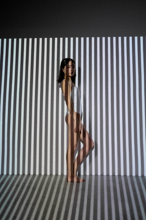 Woman Standing Near Black and White Stripe Wall