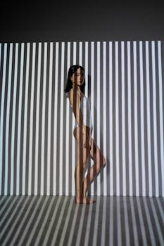 Creative photo of a woman with body suit and shadow stripes creating an illusion effect.