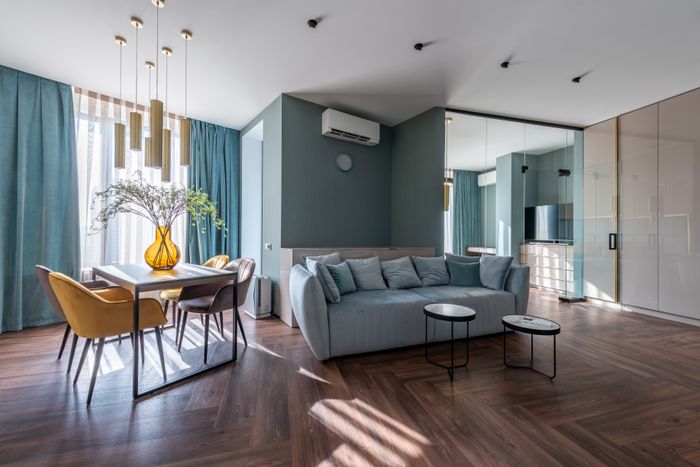 A spacious, modern living room with natural light and minimalist furniture