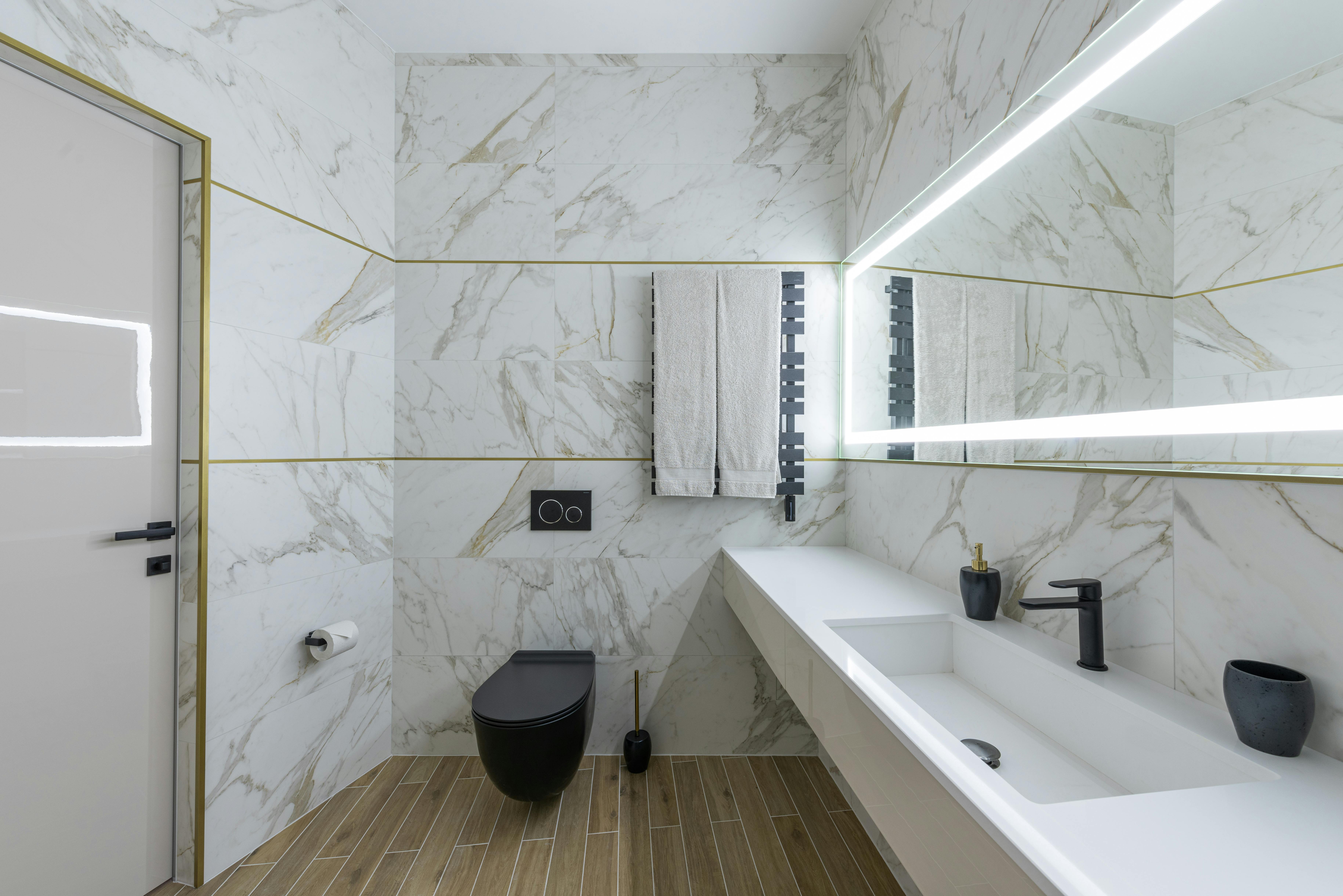 interior of modern light bathroom with parquet floor and marble walls