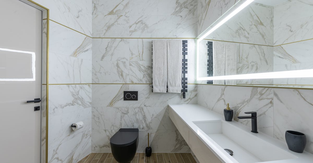 Interior of contemporary bathroom with marble walls and ceramic sink in modern minimalist apartment