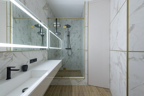 Minimalist styled bathroom with tiled walls and shower cabin