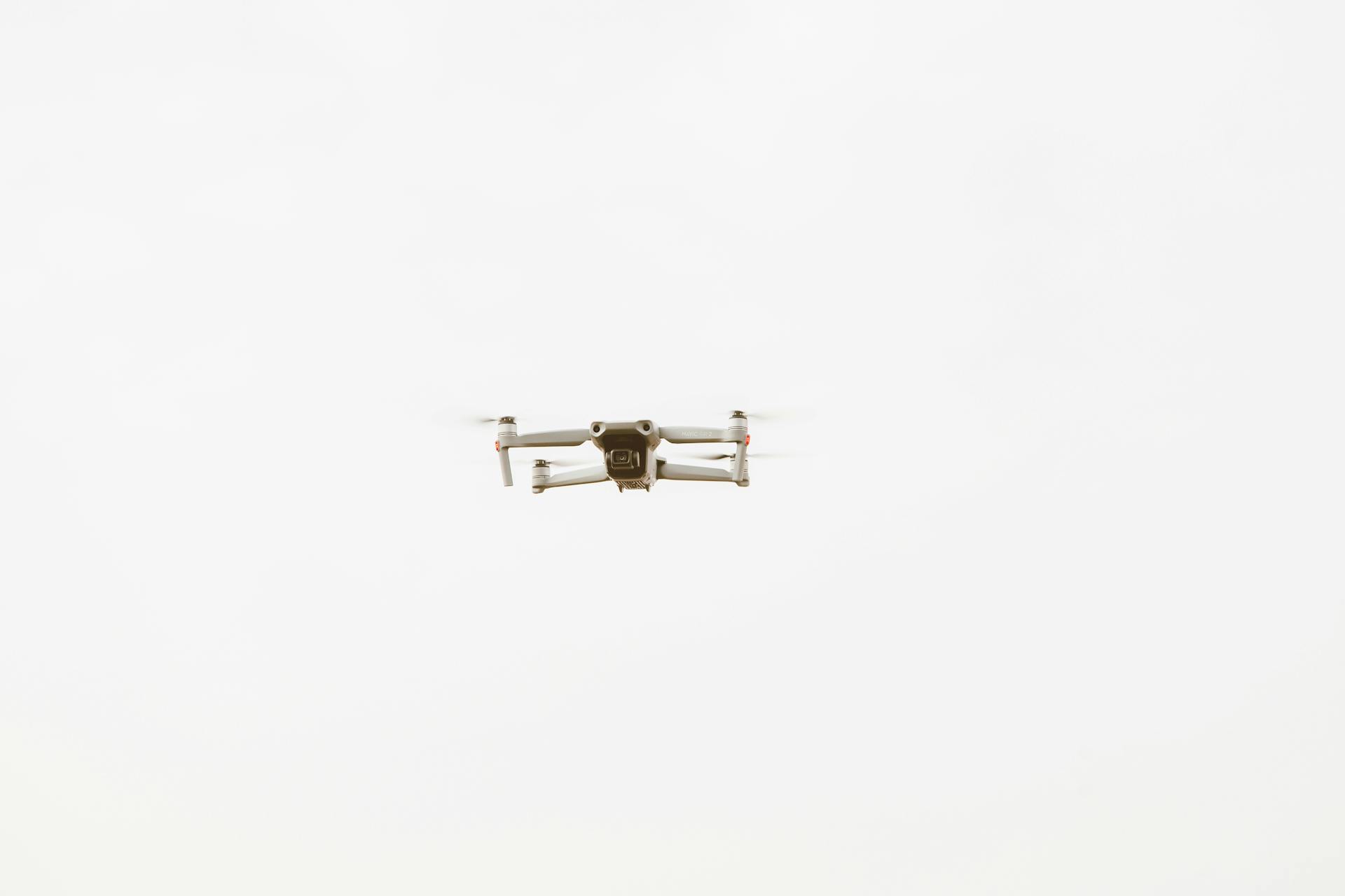 A sleek drone flying through a clear sky, showcasing modern technology.