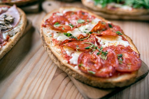 Tasty toast with pepperoni slices on cutting board