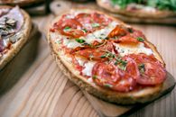 Tasty toast with pepperoni slices on cutting board