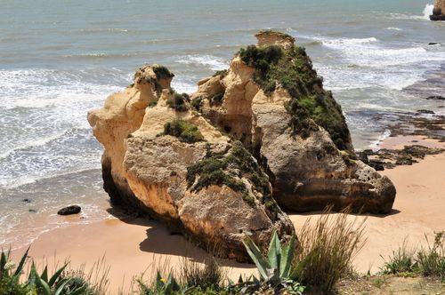 Free Explore stunning coastal rock formations along a sandy beach with vibrant ocean waves. Stock Photo