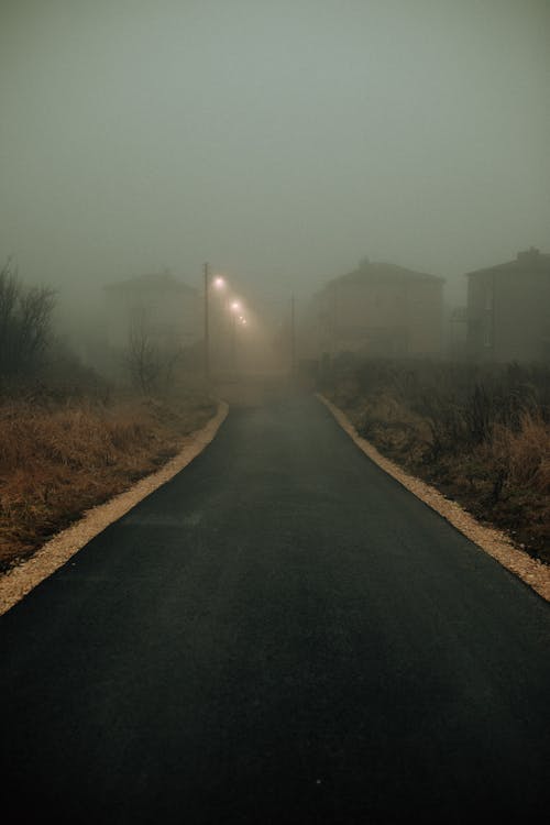 Gray Concrete Road Between Green Grass Field Near Houses