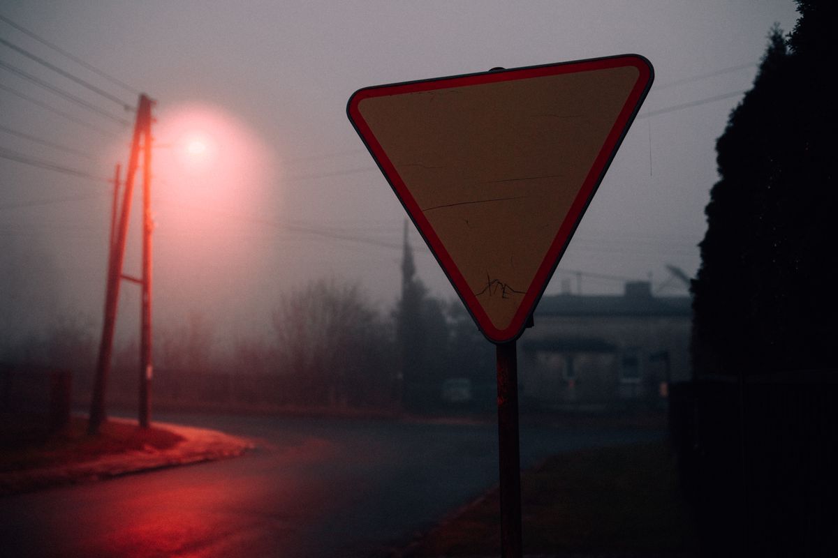 Foggy street at night illuminated by dim streetlight creating the perfect 80s horror movie atmosphere
