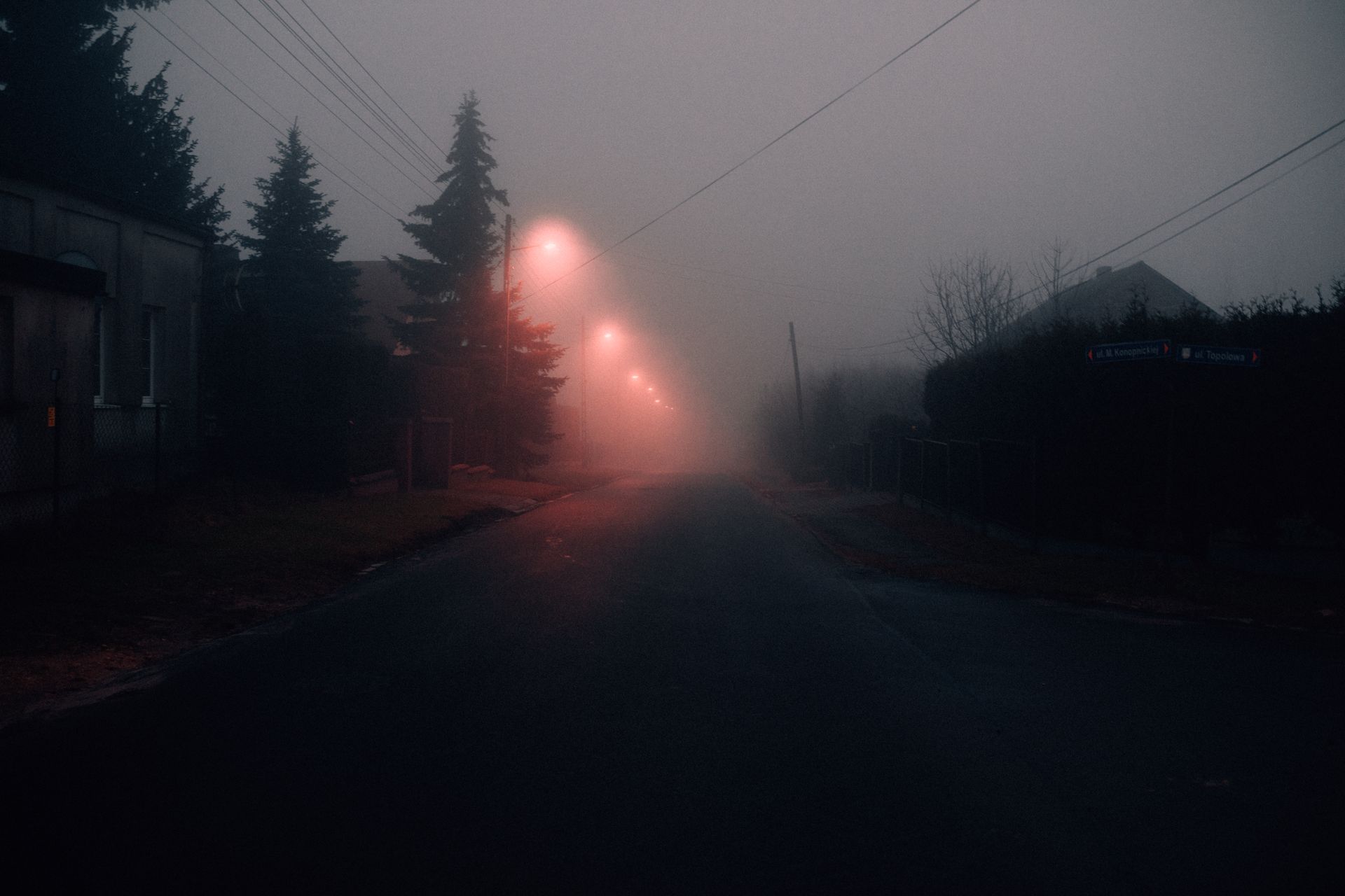 Empty village street at dusk under overcast sky.