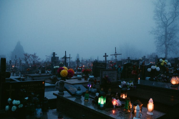 Lighted Candles And Flowers On Graves 