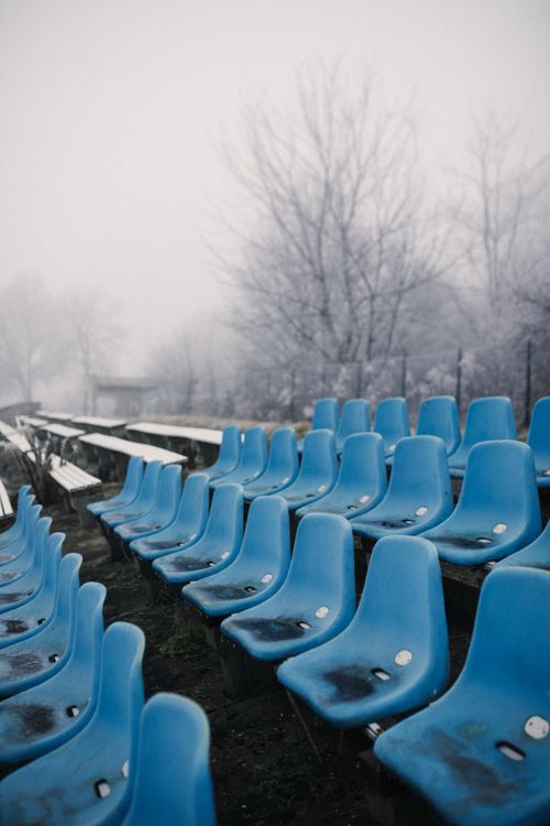 Free Empty blue seats in a foggy outdoor sports venue during winter. Stock Photo