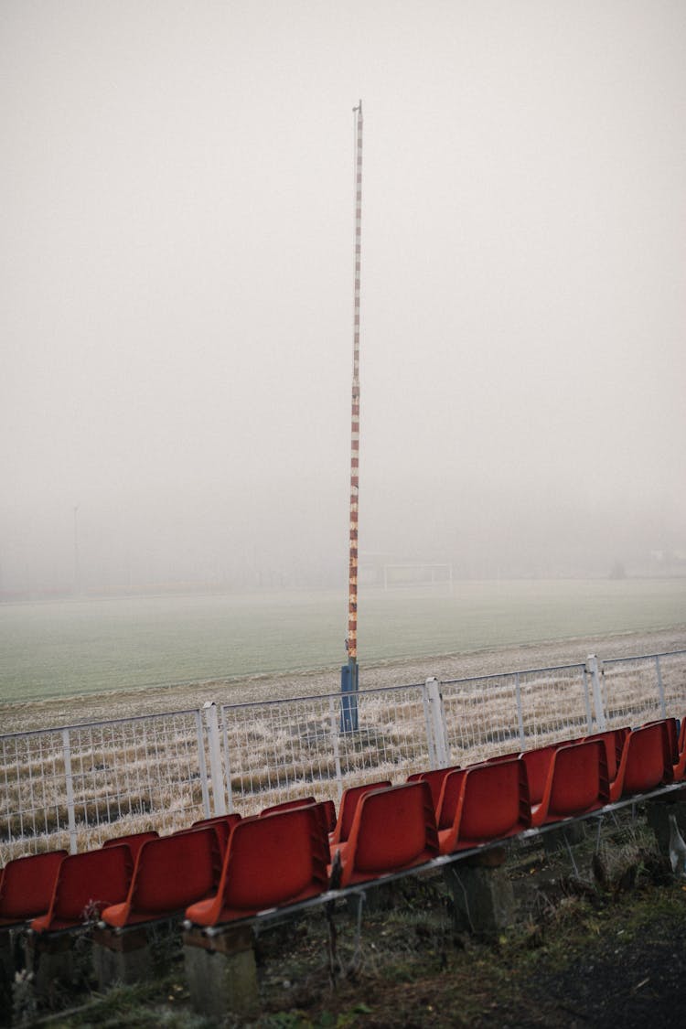 Red Plastic Seats And Stadium In Fog