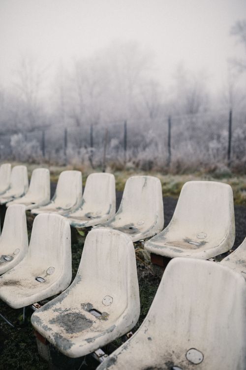 Free Desolate outdoor stadium seats covered in fog, evoking a sense of isolation and mystery. Stock Photo