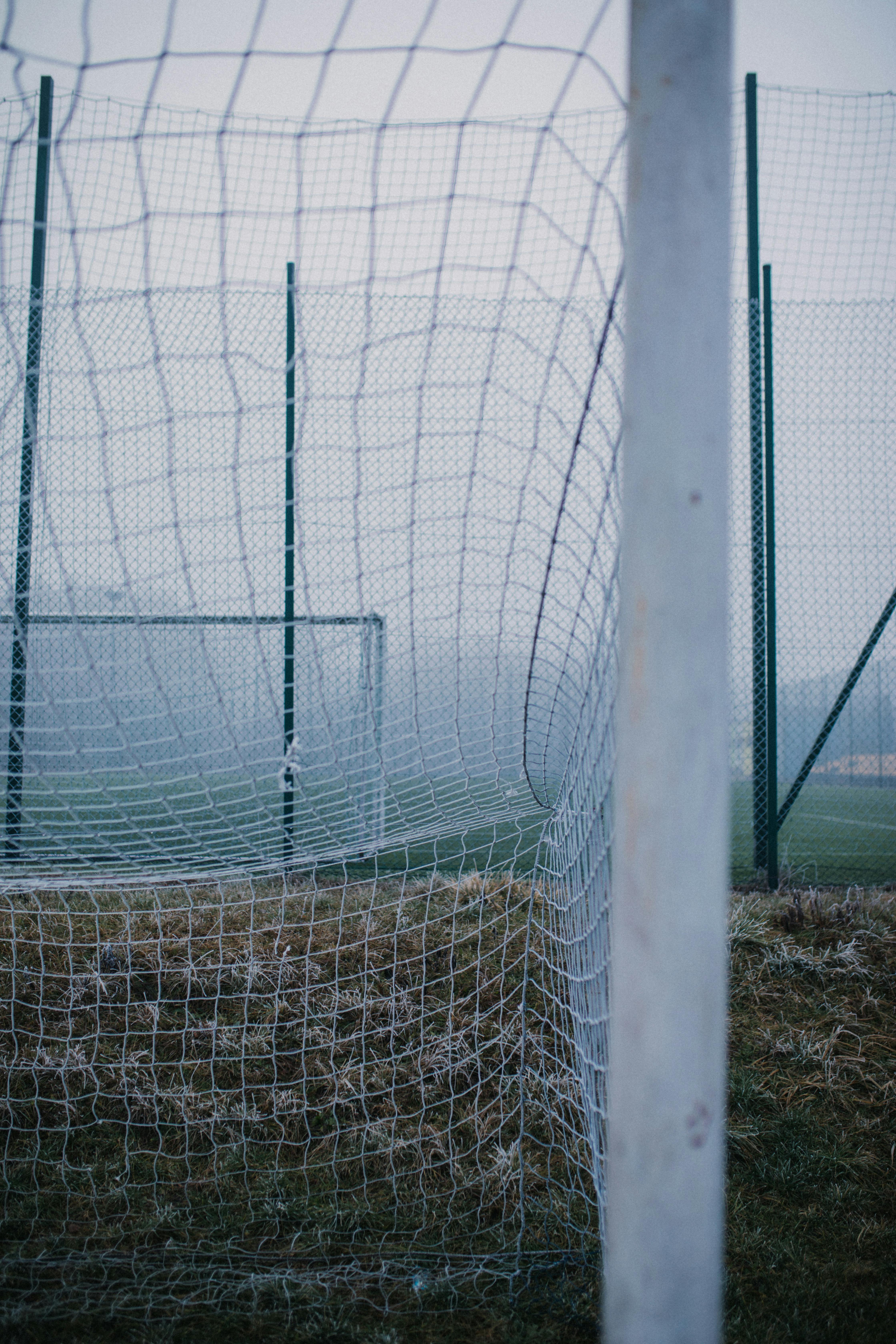 Soccer Football In Goal Net With Green Grass Field Stock Photo