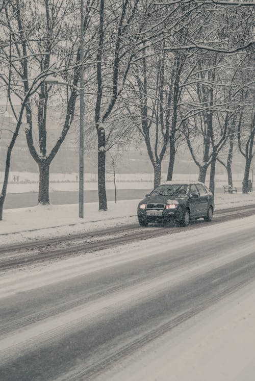 Free A Car Driving on a Snow Covered Road Stock Photo