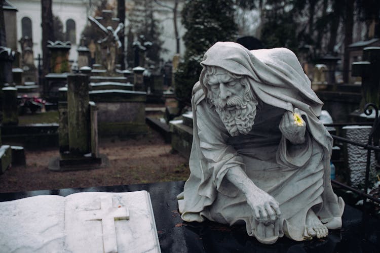 A Marble Statue On The Gravestone