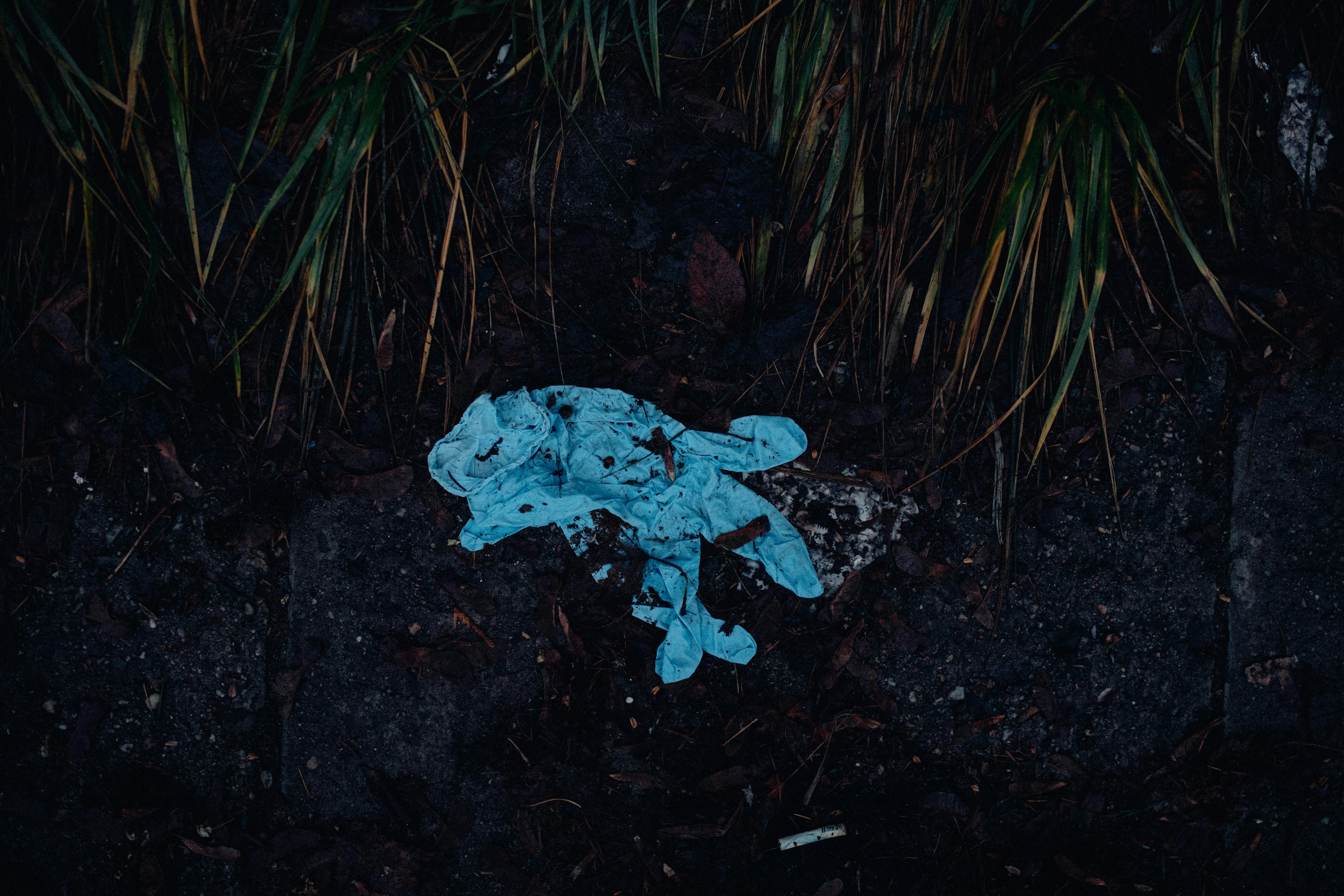 used blue latex gloves on ground