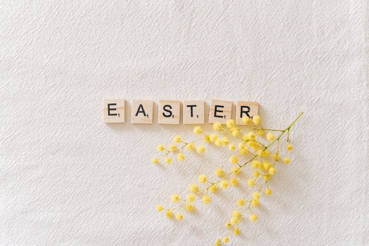 Easter Text On Gray Surface Beside Yellow Flowers