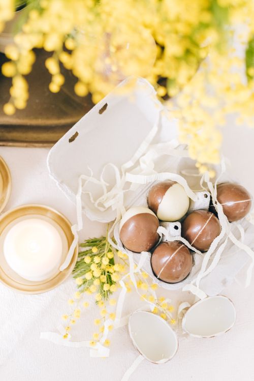 Free Top view of chocolate eggs with mimosa flowers, perfect for Easter celebration. Stock Photo
