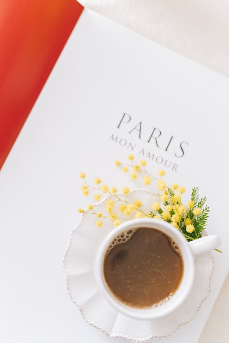 Cup Of Coffee Beside A Bunch Of Flowers