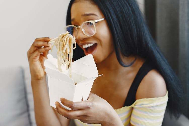 Woman Wearing Eyeglasses Eating Noddles