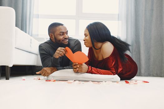 Low Angle View of a Couple Lying Down on a Floor with a Red Paper Heart