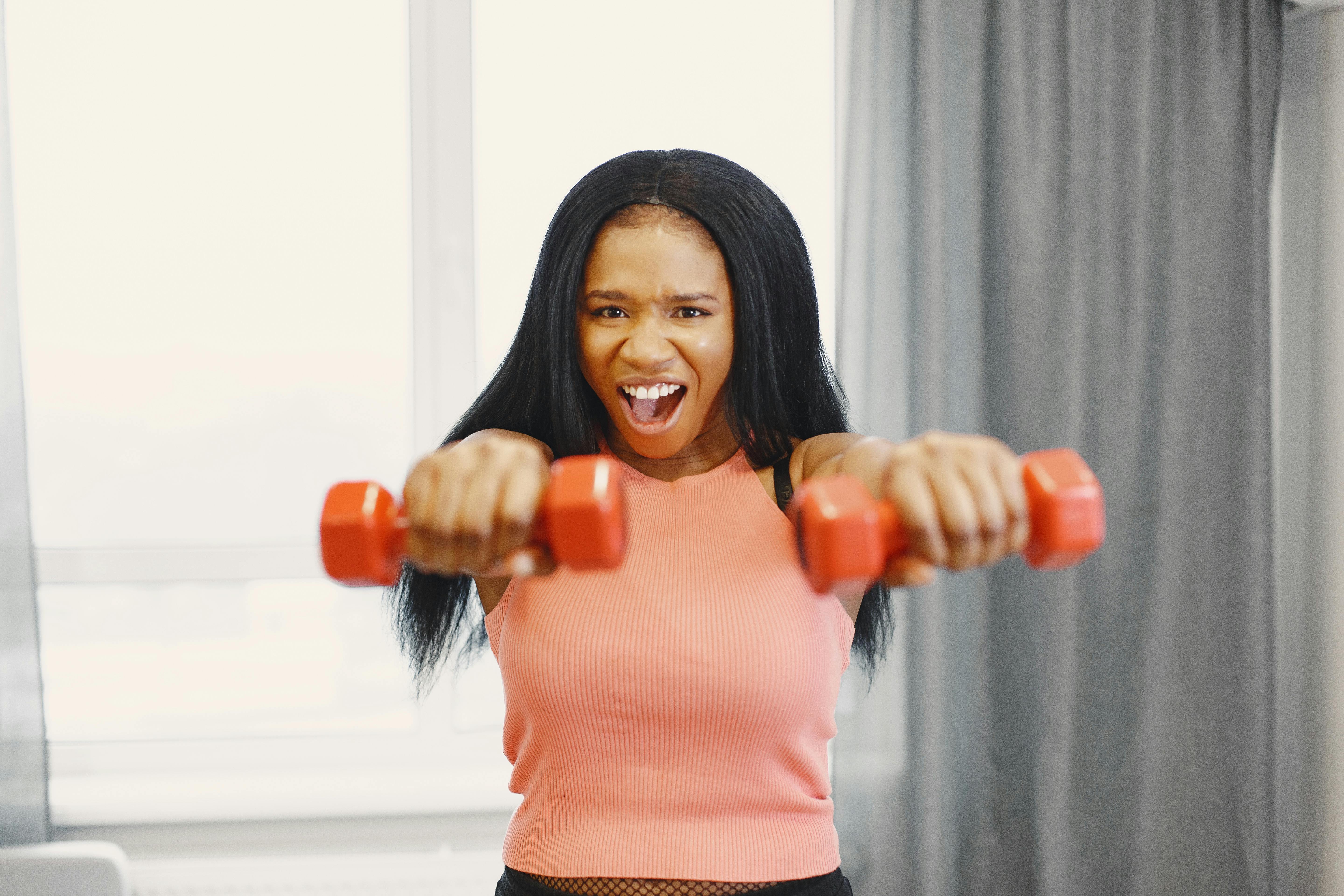 Black woman doing strength training with dumbbells to combat muscle loss