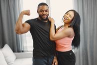 Man Flexing His Muscle Beside a Woman