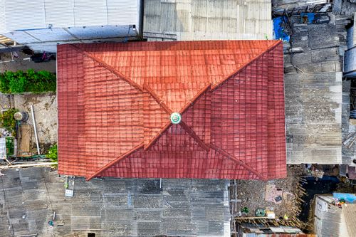 Free Aerial shot of red tiled roof surrounded by urban Jakarta, showing contrasting urban textures. Stock Photo