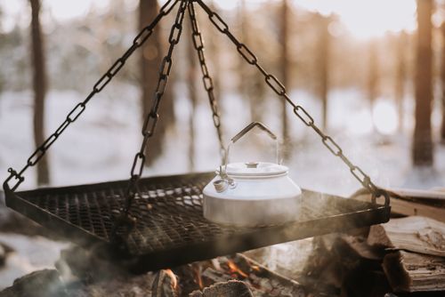 Free Close-up of a kettle steaming over a campfire in a snowy Scandinavian forest. Stock Photo