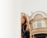 Woman standing near residential house and looking at camera