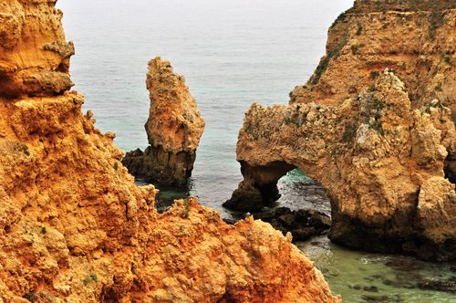 Free Explore breathtaking coastal rock formations against a calm ocean backdrop. Stock Photo