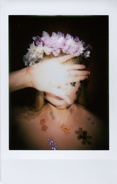 Polaroid Photo of a Woman in Wreath Covering Her Face with Her Hand