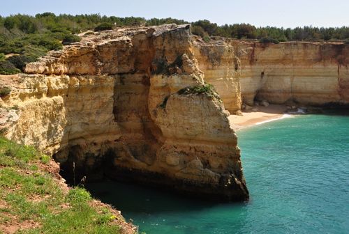 Free Stunning coastal cliff in Algarve, Portugal with turquoise water and lush vegetation. Stock Photo