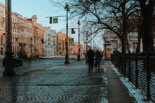 People walking on pedestrian road on city street in winter time in daylight in long exposure