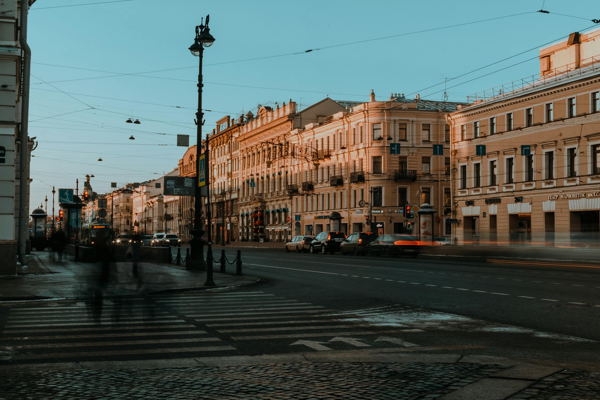 Vibrant cityscape of St. Petersburg featuring historic architecture at sunset with blurred traffic and pedestrians.