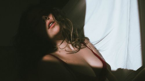 Free A captivating portrait of a woman in soft shade highlighting beauty and sensuality. Stock Photo