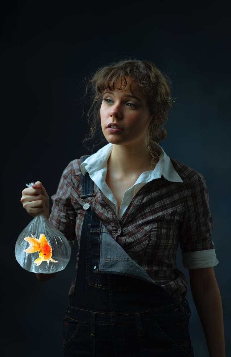 A Woman Holding A Plastic With A Goldfish