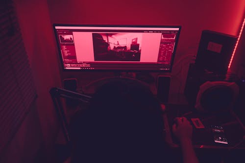 Free Person Using Desktop Computer in a Dark Room  Stock Photo