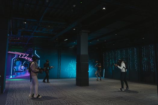 Group of young adults engaging in a futuristic virtual reality game indoors.