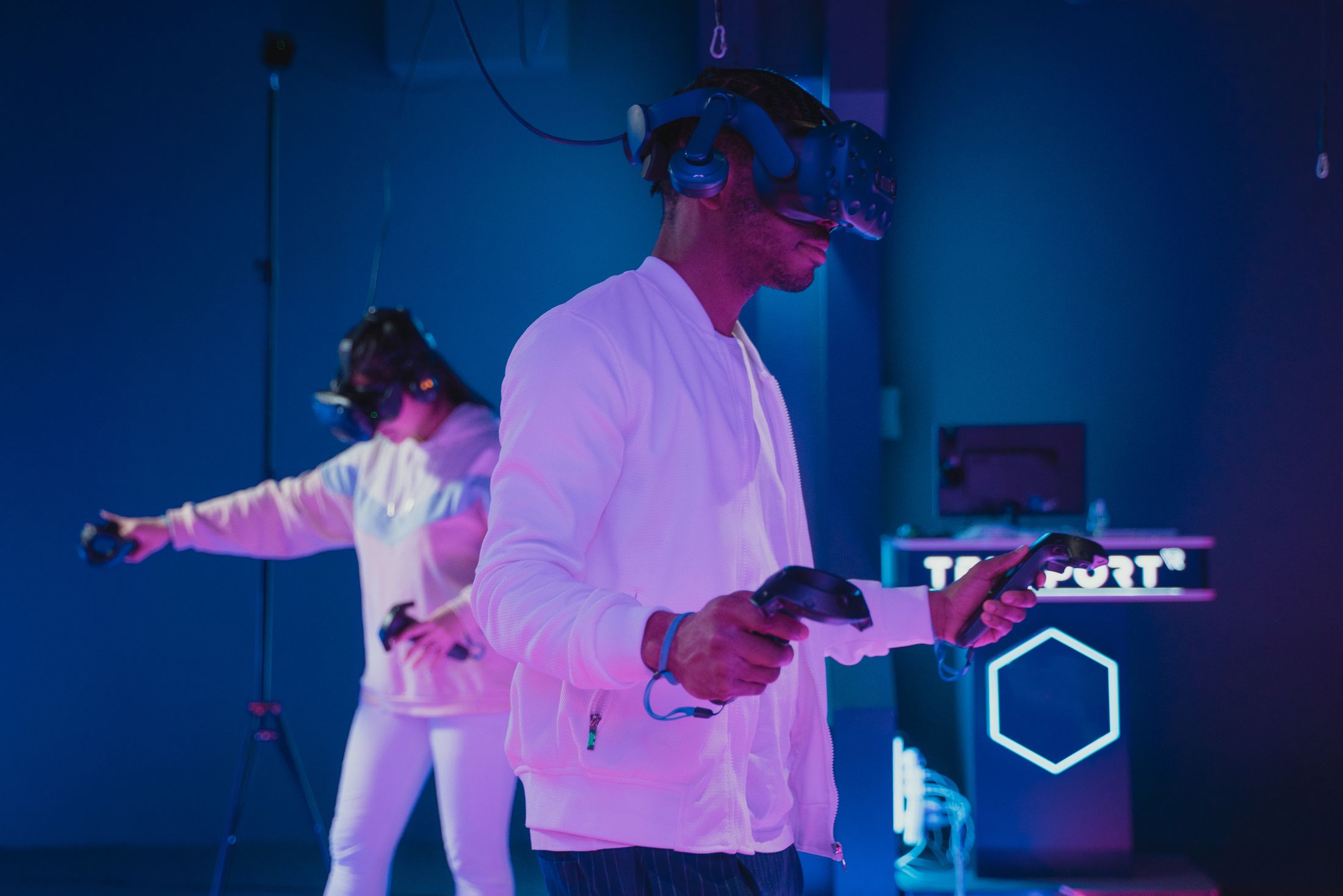 Deux personnes équipées de casques de réalité virtuelle dans un espace de jeu