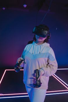 A woman in a hoodie enjoying virtual reality gaming in a neon-lit room.