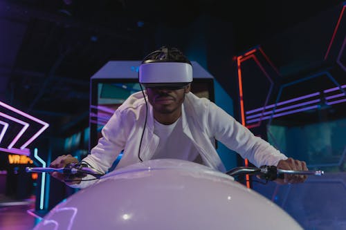 Free A Man in a Simulation of Riding a Motorcycle with a VR Headset Stock Photo