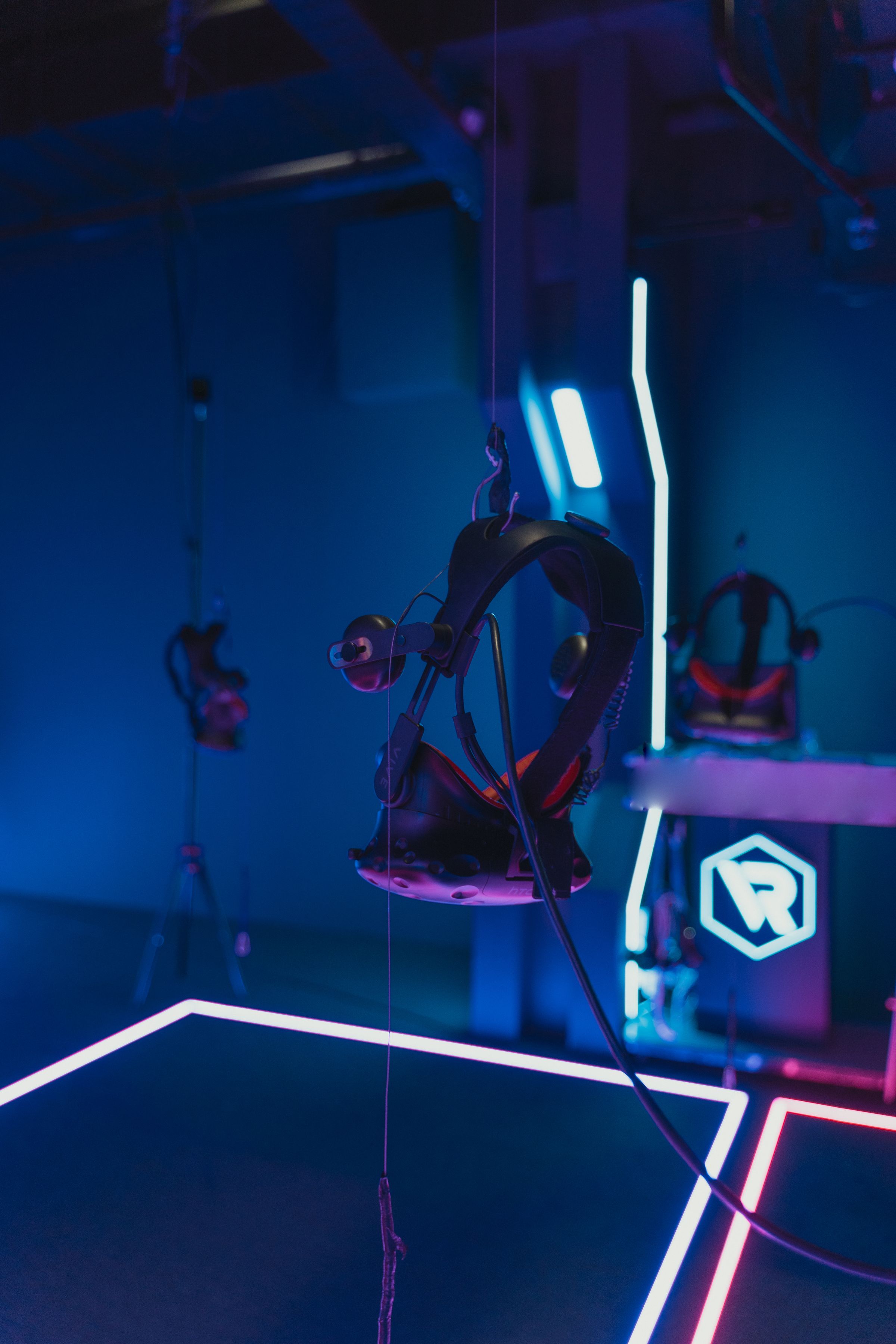 Virtual reality headsets arranged inside a dark gaming space