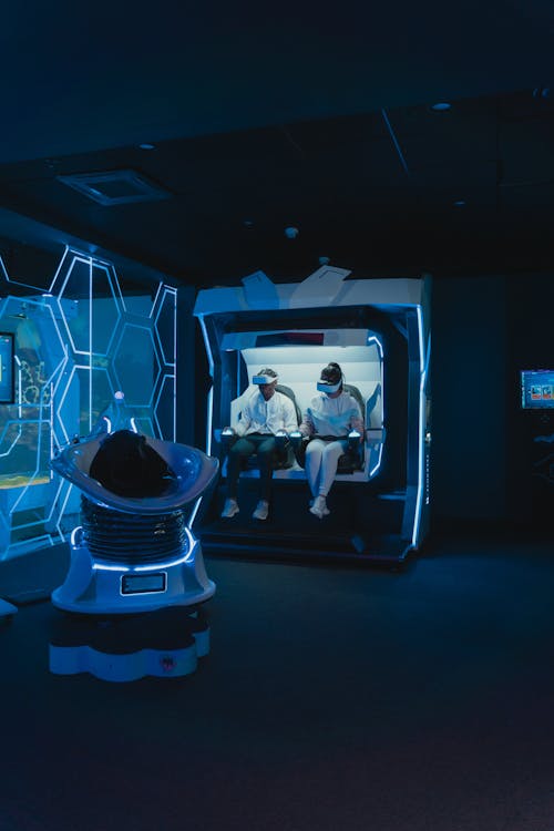 A Man and a Woman Riding a Virtual Reality Simulator