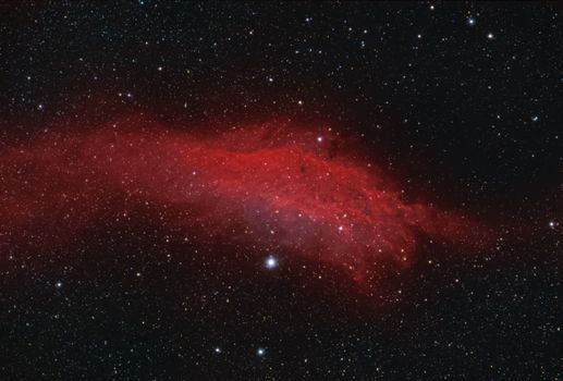A stunning cosmic view featuring a red nebula surrounded by a field of stars.