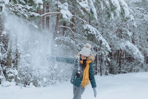 Woman in Green Jacket playing With Snow