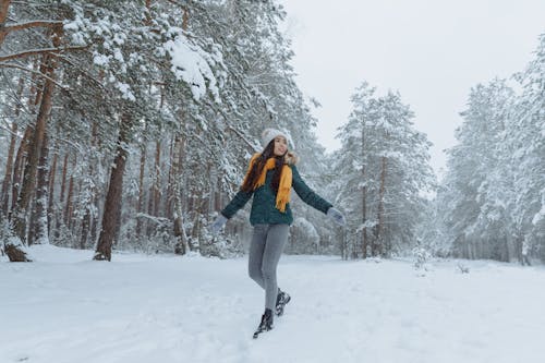 Woman in Green Jacket standing on Snow Covered Ground