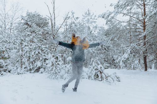 Free Woman enjoying the snow in a winter landscape, displaying fun and happiness. Stock Photo