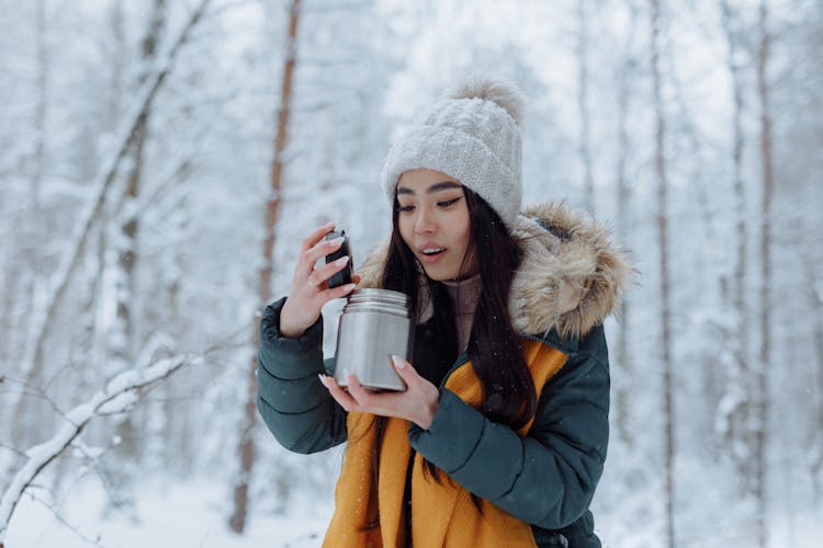 Woman In Winter Clothes Holding A Thermos